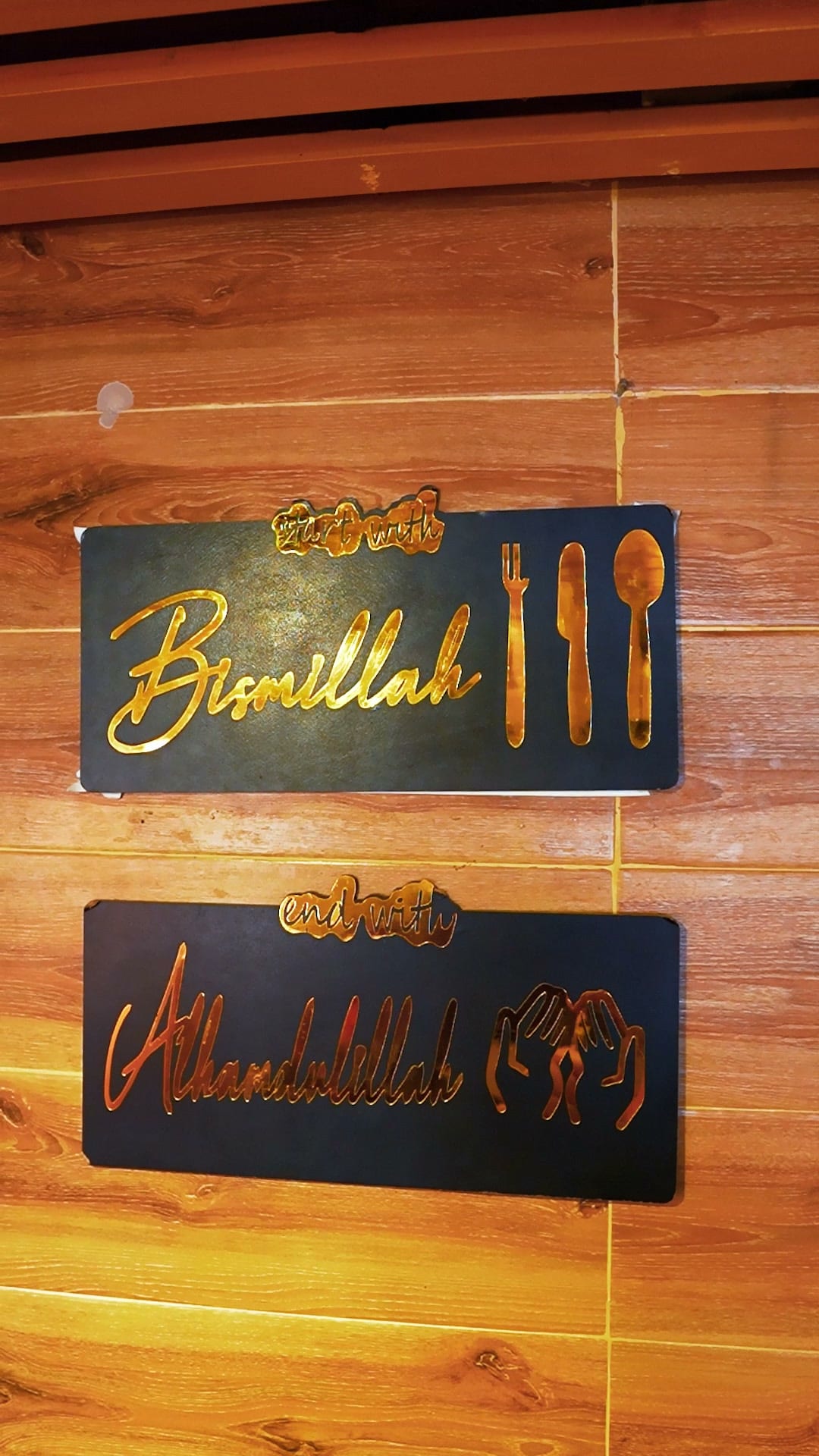Bismillah and Alhamdulillah plaques mounted on the wooden wall of the Sufraq dining room